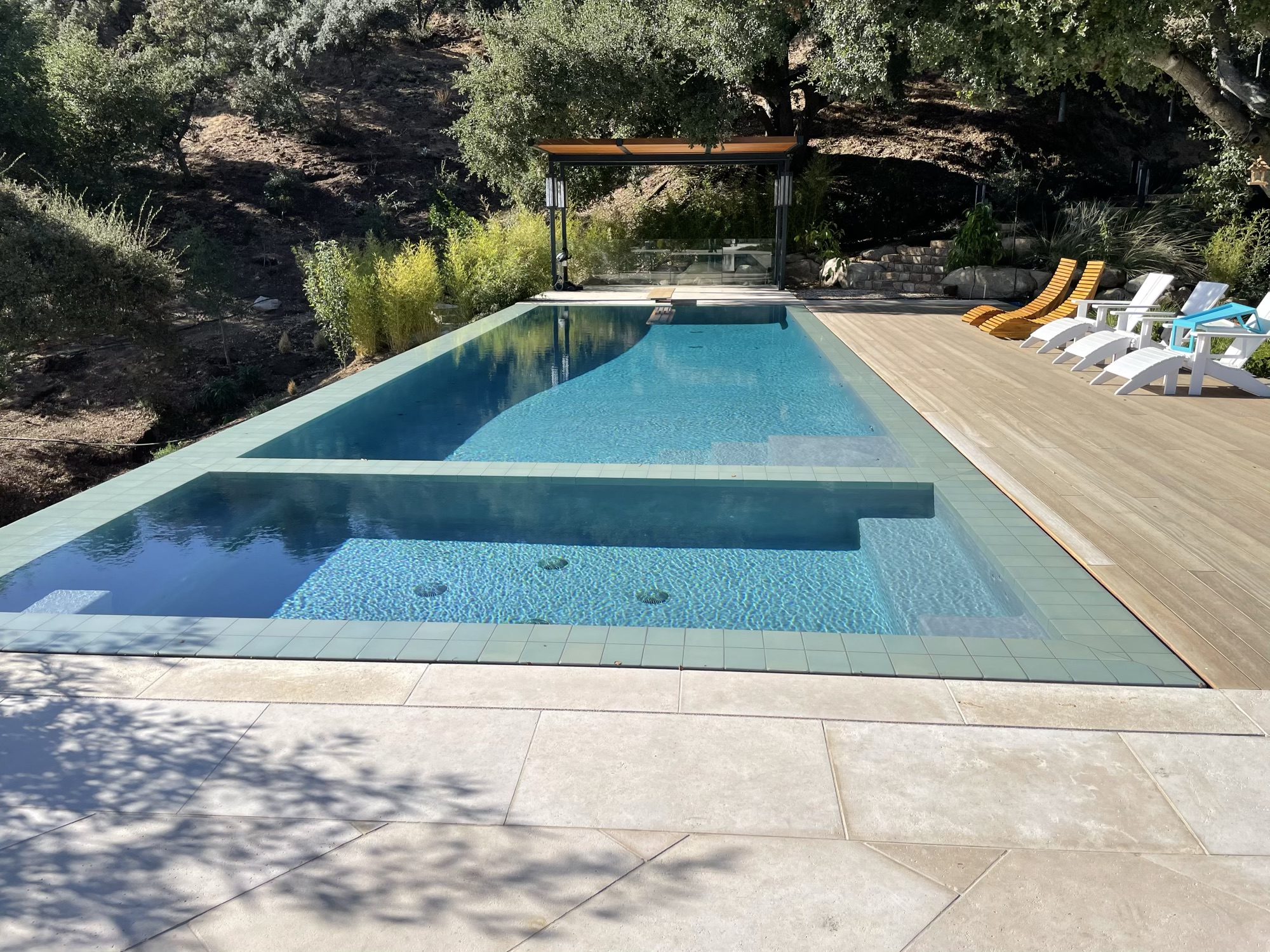 Modern pool and spa with hillside view